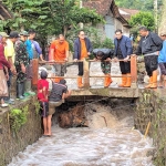 Pj Gubernur Adhy Karyono bersama rombongan saat meninjau jembatan di Sungai Peh, Desa Gunungsari, yang terhambat material banjir bandang, seperti, sampah, kayu, dan bambu.