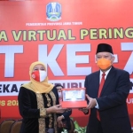 Gubernur Jawa Timur Khofifah Indar Parawansa saat menerima uang baru pecahan Rp 75.000 dari Kepala Kantor Perwakilan BI Jatim, Difi Ahmad Johansyah usai upacara virtual 17 Agustus di Gedung Negara Grahadi, Senin (17/8). foto: ist/ bangsaonline.com