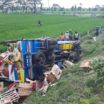 Truk bermuatan cabe yang terguling di sisi kiri jalan tol.