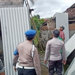 Anggota TN-Polri sedang membersihkan sisa-sisa atap rumah warga akibat terjangan puting beliung.
