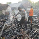 Polisi saat melakukan olah TKP di rumah korban yang terbakar. foto: ZAINAL ABIDIN/ BANGSAONLINE