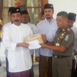 Koordinator Barisan Santri Merah Putih (BSMP), KH. Fakhrurrozi menyerahkan surat mandat dukungan kepada Pakde Karwo di rumah dinas gubernur di komplek Gedung Grahadi. foto: DIDI ROSADI/ BANGSAONLINE