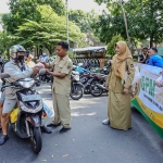 Petugas saat melayani warga yang membeli bahan pangan murah. Foto: Ist