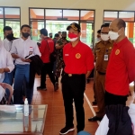 Kolonel Inf Fahmi Sudirman (kanan kaos merah) dan Bupati Trenggalek, Moch. Nur Arifin, saat meninjau lokasi vaksinasi masal di SMKN I Pogalan, Trenggalek. Foto: HERMAN SUBAGYO/ BANGSAONLINE