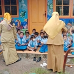 Murid-murid PAUD dan TK terpaksa belajar di teras depan ruang kelas yang disegel. 