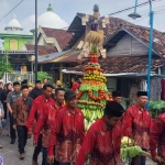 Warga Desa Dooro saat membawa gunungan berupa hasil bumi dalam sedekah bumi. Foto: Ist