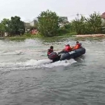 Petugas gabungan saat menyisir sekitar lokasi tenggelamnya 2 balita di Sungai Rolak, Surabaya.