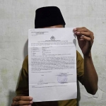 Korban AF, seorang mahasiswa UIN Madura menunjukkan bukti laporan polisi usai dikeroyok sesama mahasiswa. Foto: DIMAS M. S./ BANGSAONLINE