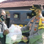 Kapolres Ngawi AKBP I Wayan Winaya menyerahkan bantuan kepada masyarakat.