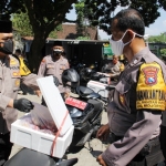 Kapolres Kediri Kota AKBP Wahyudi (kiri) saat menyerahkan daging kurban yang sudah dikemas kepada petugas bhabinkamtibmas untuk selanjutnya dibagikan kepada warga secara door to door. foto: ist.