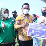 Bupati Gresik, Fandi Akhmad Yani, saat menyerahkan bonus kepada atlet didampingi Ketua KONI, Sekda, dan Kadispora setempat. Foto: SYUHUD/ BANGSAONLINE