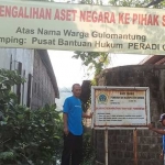 Ketua RT 7 RW 2 Desa Gulomantung, Achmad Zainul Agus (kiri) bersama warga menunjukkan aset pemerintah yang akan disewakan ke swasta. Foto: SYUHUD/ BANGSAONLINE.com