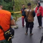 Petugas saat mengecek jalan yang amblas akibat bencana beberapa waktu lalu.