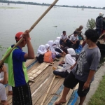 Sejumlah pelajar dan warga terpaksa menggunakan perahu untuk beraktivitas sehari-hari. foto: SUWANDI/ BANGSAONLINE