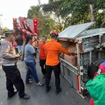 Kondisi mobil pikap bermuatan oli dan suku cadang saat terguling di Jalan Jemursari, Surabaya, Senin (21/7/2025)