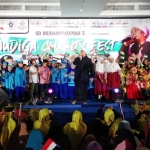 Penampilan Opick saat menghibur para tamu undangan, dilatarbelakangi murid-murid SD Muhammadiyah 3 Surabaya yang membawa bendera Palestina dan bendera Merah Putih berukuran kecil. Foto: YUDI ARIANTO/BANGSAONLINE
