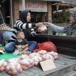 Ilustrasi fluktuasi. Seorang pedagang saat telur melayani pembeli. (Ist)