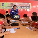 Para pelajar saat sedang belajar secara online didampingi kakak-kakak karang taruna setempat. (foto: ist).