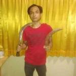 SAKIT HATI: Tersangka Doni memamerkan celurit yang dipakai menyabet punggung atasannya. foto: realita