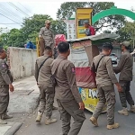 Satpol PP Kota Proboliggo saat menertibkan dagangan PKL yang masih berjualan di atas trotoar alun-alun.