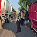 Anggota Satlantas Polres Lamongan saat hendak mengevakuasi truk yang terlibat laka
