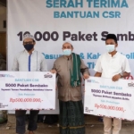 General Manager of CSR SIG, Edy Saraya (kanan) menyerahkan bantuan paket sembako secara simbolis kepada pengurus yayasan Brilian Azzahra Arifin dan yayasan  YPTNU di Probolinggo. foto: ist.