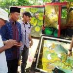 Rasiyo berbincang dengan M Anis seniman lukis yang didatanginya di Bantaran Sungai Ketabang Kali. foto: maulana/BANGSAONLINE