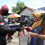 Para petugas sedang membagikan masker di Pasar Krempyeng Dukuh Bulak Banteng dan Pasar Podomoro.?