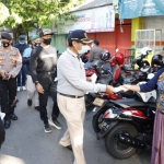 Bupati Tuban H. Fathul Huda saat membagikan maske ke salah satu pengunjung pasar.