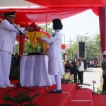 Pj Bupati Nganjuk Sudjono saat menyerahkan bendera kepada petugas Paskibraka. Foto: BAMBANG/ BANGSAONLINE