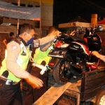 Petugas mengangkut salah satu motor.