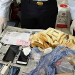Petugas Lapas Kediri saat mengamankan barang bukti berupa roti tawar yang berisi HP dan charger. Foto: Ist