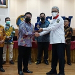 Kepala Diskominfotik Kota Pasuruan Kokoh Arie Hidayat menyerahkan kenang-kenangan usai penandatanganan kerja sama dengan BSSN, Depok, Rabu (20/7/22).