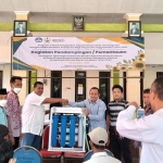 SIMBOLIS: Tim Dosen Unipa Surabaya menyerahkan alat penjernih air ke Desa Simpang Prambon, Sidoarjo, Rabu (21/12/2022). Foto: Ist.