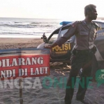 Papan peringatan yang dipasang petugas di pinggir pantai Serang. foto: AKINA/ BANGSAONLINE