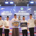 Syaifullah Mahdi, peraih juara I Kontes Bandeng Kawak 2026 saat menerima hadiah dari Bupati Gresik, Fandi Akhmad Yani. Foto: Ist