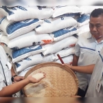 Kepala Perum Bulog Cabang Kediri Mara Kamin Siregar (kiri), menunjukkan contoh beras yang akan didistribusikan kepada KPM di Kabupaten Kediri, Kota Kediri, dan Kabupaten Nganjuk. foto: MUJI HARJITA/ BANGSAONLINE