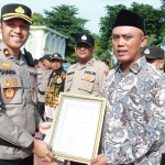 Wakapolres Gresik, Kompol Shabda Purusha Putra (kiri), menyerahkan penghargaan kepada salah satu tokoh masyarakat. Foto: Ist
