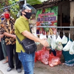 Efendi Muhtar, Ketua RT 01 dan Sunaryo Ketua RW 01, saat menata sayur di cantelan. foto: MUJI HARJITA/ BANGSAONLINE