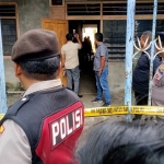 Petugas Polres Tuban memasang garis polisi di rumah kosong yang menjadi lokasi temuan granat.