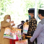 Wali Kota Risma menyerahkan menyerahkan bantuan 2 setel baju hazmat, 1 boks masker medis, dan 1 boks sarung tangan kepada para modin di Kota Surabaya di Halaman Balai Kota Surabaya, Rabu (25/11/2020). (foto: ist)
