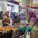 Hj. Dumatul Holisah Ketua DPC  PB Bangkalan saat menyambangi booth UMKM Bangkalan di acara IWF. Foto: AHMAD FAUZI/ BANGSAONLINE