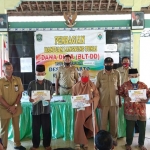 Babinsa Jokarto Koramil 0821/10 Tempeh, Serda Imam Wahyudi saat mendampingi kegiatan penyaluran BLT DD Tahap II yang bertempat di Balai Desa Jokarto, Kecamatan Tempeh, Kabupaten Lumajang, Senin (8/6/2020).