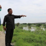 Ketua DPRD Gresik Moh. Abdul Qodir (kanan), didampingi Subbagian Informasi Kehumasan dan Protokol, Jhonis Wahyu Basuki saat meninjau tanggul Kali Lamong. foto: ist.