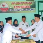 Kakankemenag didampingi Penyelenggara Syariah memberikan bantuan kepada Kepala KUA Merakurak, Idris.