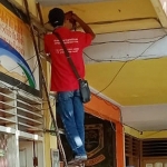 Petugas tampak memasang CCTV di salah satu sudut sekolah.