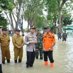 Kapolres Gresik AKBP Rovan Richard Mahenu bersama Kepala BPBD Kabupaten Gresik Sukardi, meninjau lokasi yang dilanda banjir di Kecamatan Benjeng, Gresik, Jawa Timur, Selasa (10/6/2025). Foto: Dok. Polres Gresik