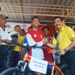 Sigit pemenang lari 8000 m menerima hadiah berupa sepeda gunung dari Wakil Bupati Gresik Moh. Qosim. foto: SYUHUD/ BANGSAONLINE