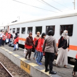 Suasana saat Polwan Polresta Malang Kota naik kereta bersama para penyandang disabilitas.