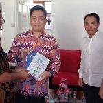 Dekan FH Uniska, Zainal Arifin (kiri), saat menyerahkan cendera mata berupa buku kepada Ketua PN Kota Kediri. Foto: Ist